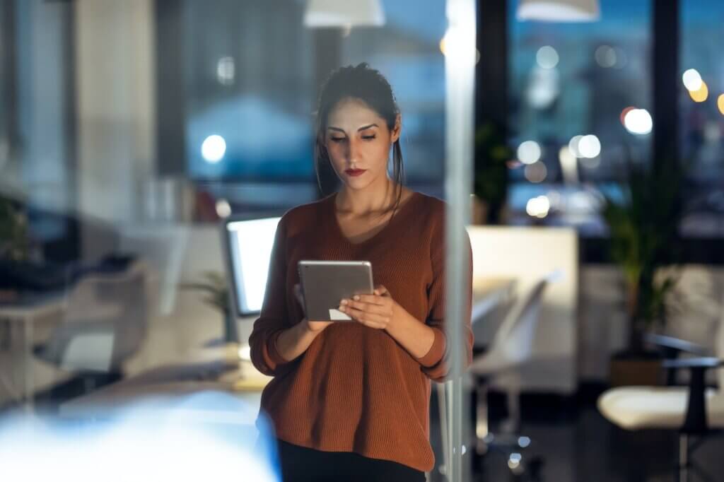 Smart pretty business woman taking a break cheaking her digital tablet in the office.